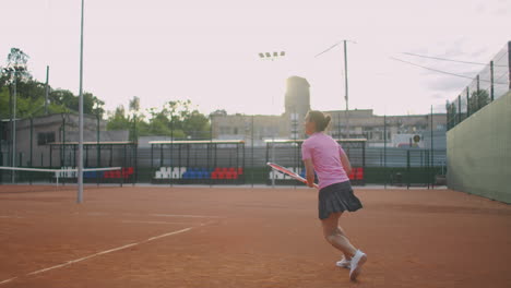 Seitenansicht-Einer-Jungen-Kaukasischen-Frau,-Die-Auf-Einem-Platz-Tennis-Spielt-Und-In-Zeitlupe-Einen-Ball-Zurückschlägt